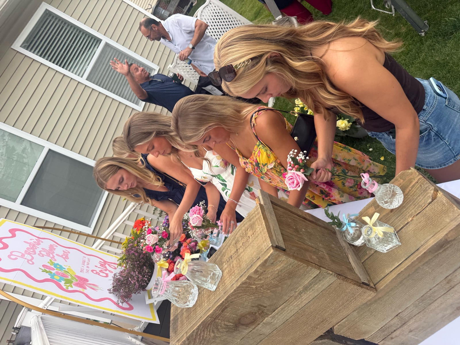 At a BBB gathering · Guests arranging pink roses together at an outdoor celebration