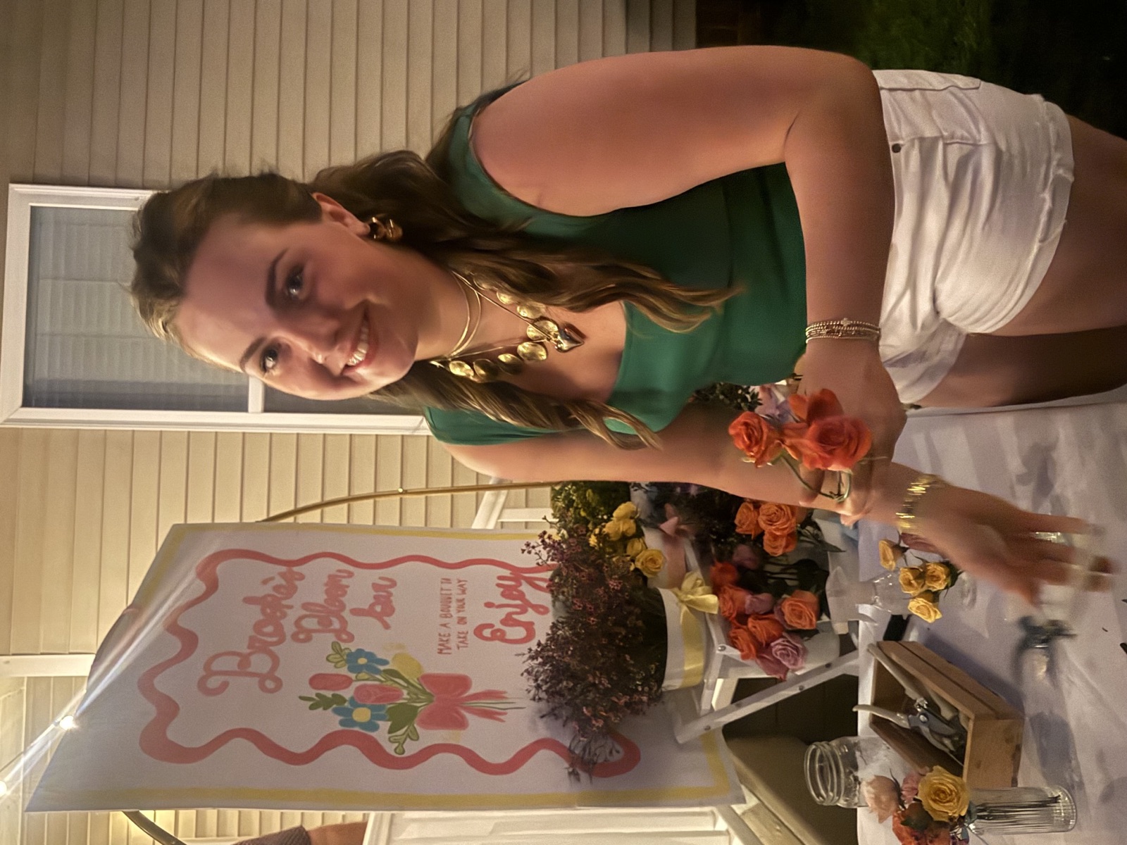 At a BBB gathering · A smiling guest holding roses beside the flower bar